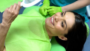 cosmetic dentistry pearland tx, woman in dentist chair looking at her smile in mirror