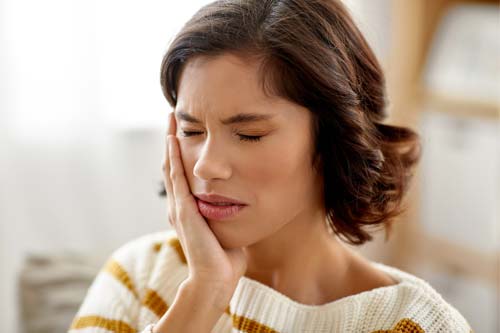 emergency-dental-services (5) woman experiencing a toothache and needing to seek emergency dental services