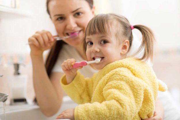 how-to-prevent-teeth-shifting (8) child and mother brushing teeth to prevent teeth shifting