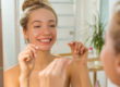 woman at bathroom mirror experiencing benefits of flossing daily