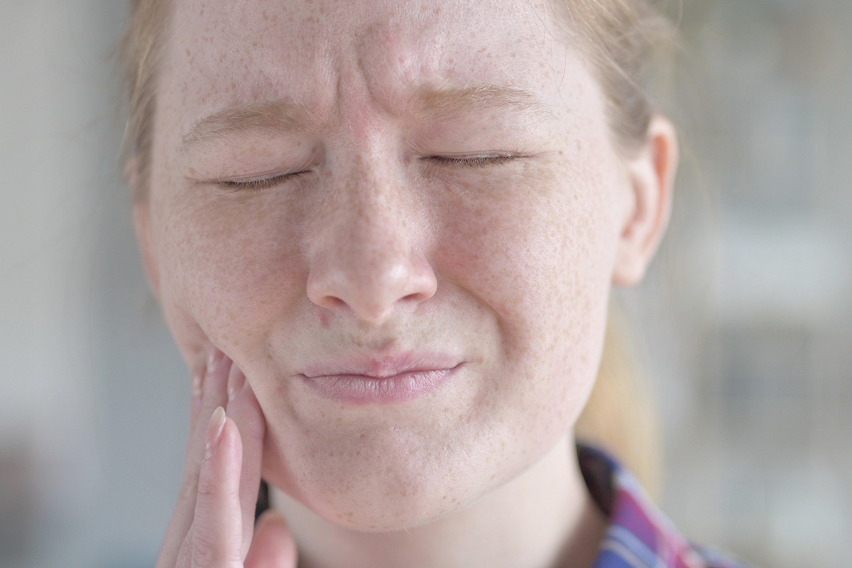 how does tooth decay develop woman holding side of mouth experiencing how does tooth decay develop