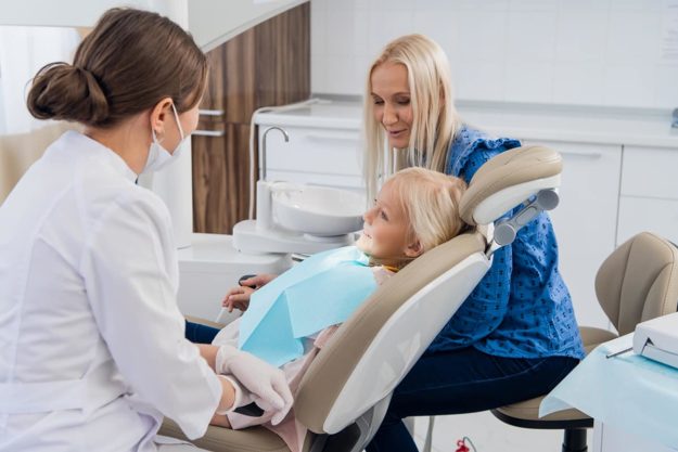 a mother taking her daughter to the family dentist
