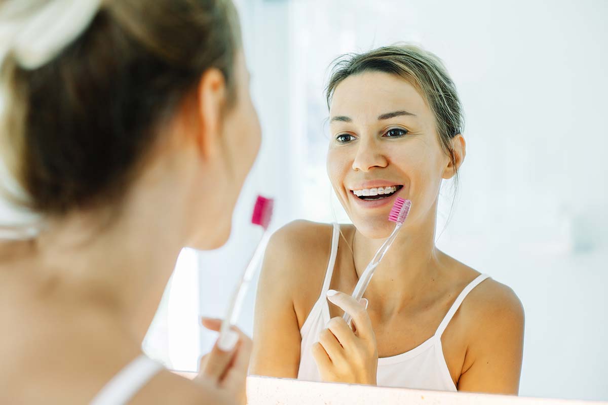 woman brushing with braces