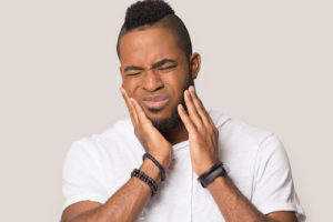 a man feeling pain from Impacted Teeth 