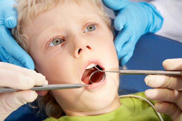 Finding A Pediatric Dentist for Your Child young boy visiting a pediatric dentist